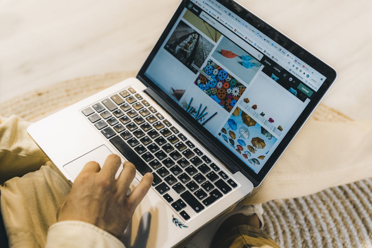 services-02 Une personne utilisant un ordinateur portable pour parcourir des sites de photos de stock. Travail freelance dans un cadre chaleureux.